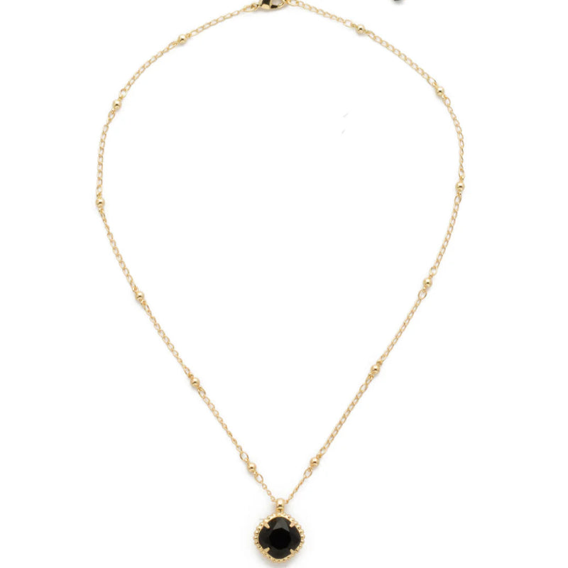 Gold necklace with a black pendant on a white background